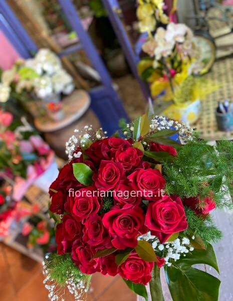 Bouquet di rose rosse confezionato con verdi selezionati.per un evento speciale